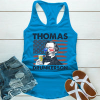 Blue tank top with graphic design of a historical figure and text, paired with denim shorts and sandals on a wooden surface.