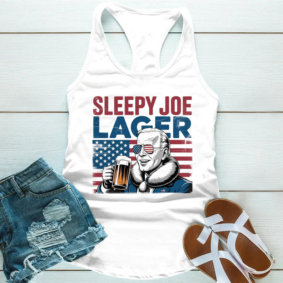 White tank top with 'Sleepy Joe Lager' graphic, denim shorts, and sandals on a light wooden surface.