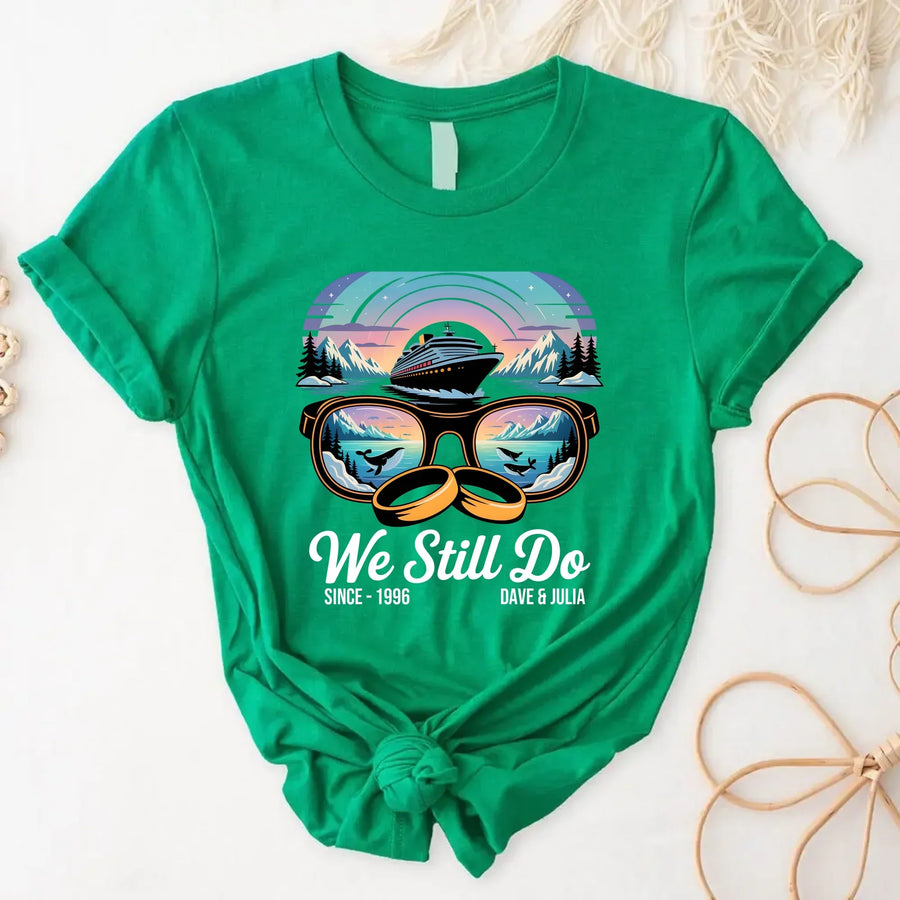 Green t-shirt with cruise ship and ocean sunset design, "We Still Do" anniversary graphic