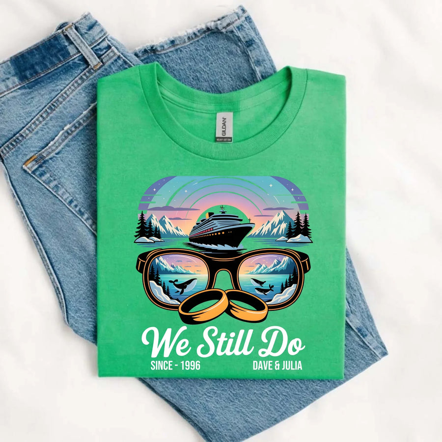 Green custom graphic tee with cruise ship, sunglasses, wedding rings, and 'We Still Do' text, styled with blue jeans.