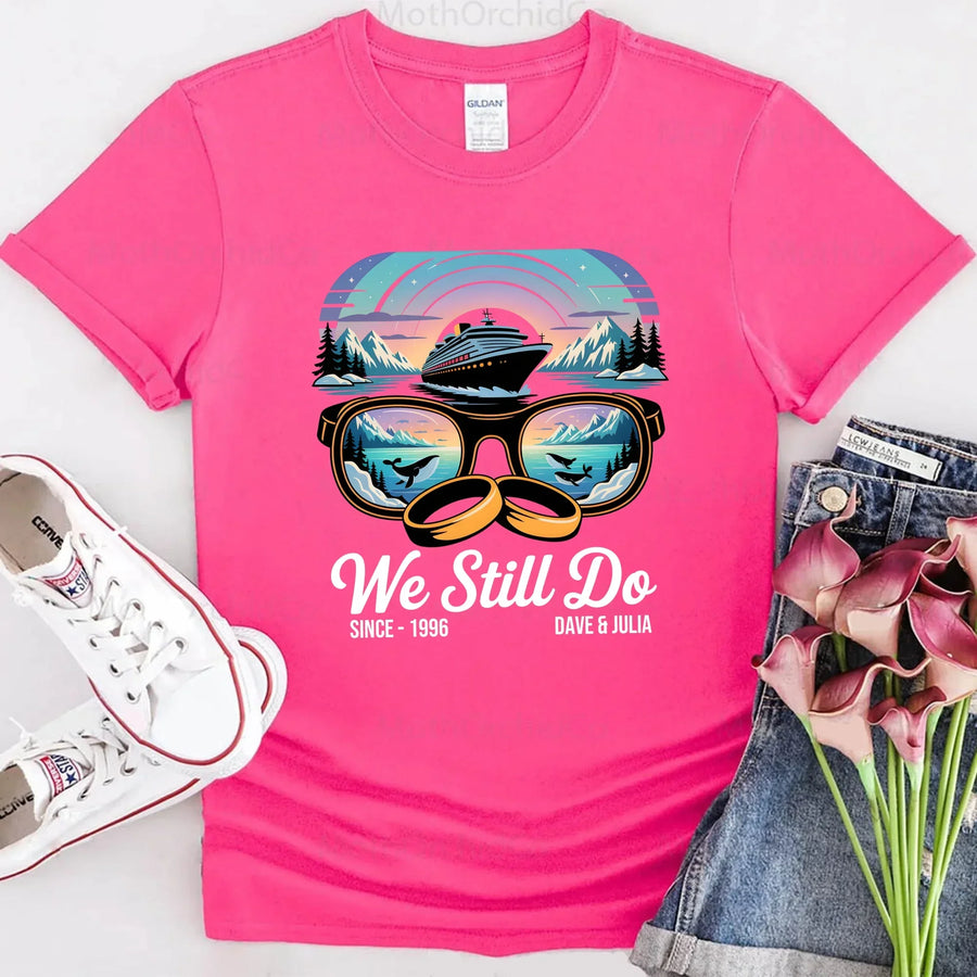 Pink custom t-shirt with cruise ship, sunglasses, rings, mountains, and 'We Still Do' text design