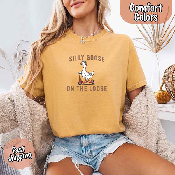 May include a woman wearing a mustard Comfort Colors t-shirt with the phrase 'Silly Goose On The Loose' — styled in a lighthearted, casual outfit great for gifting or everyday fun