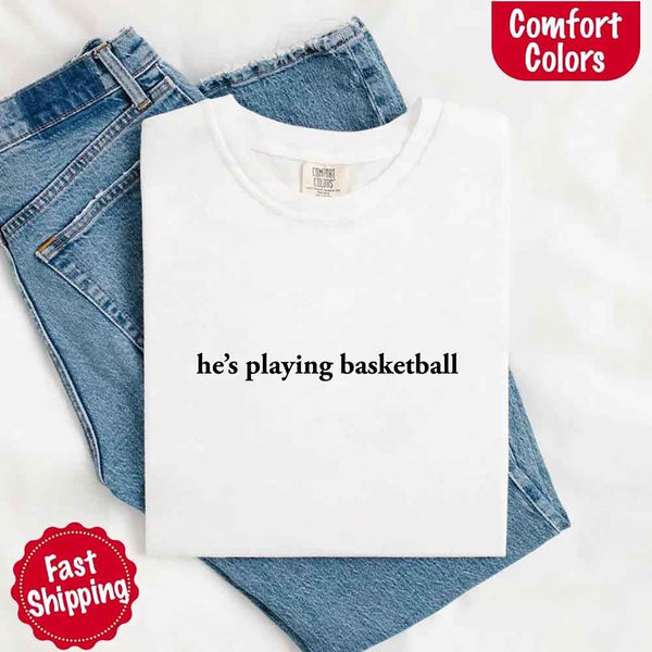 May include a folded white Comfort Colors T-shirt with “he’s playing basketball” printed in black, laid on denim jeans for a clean, sporty vibe.