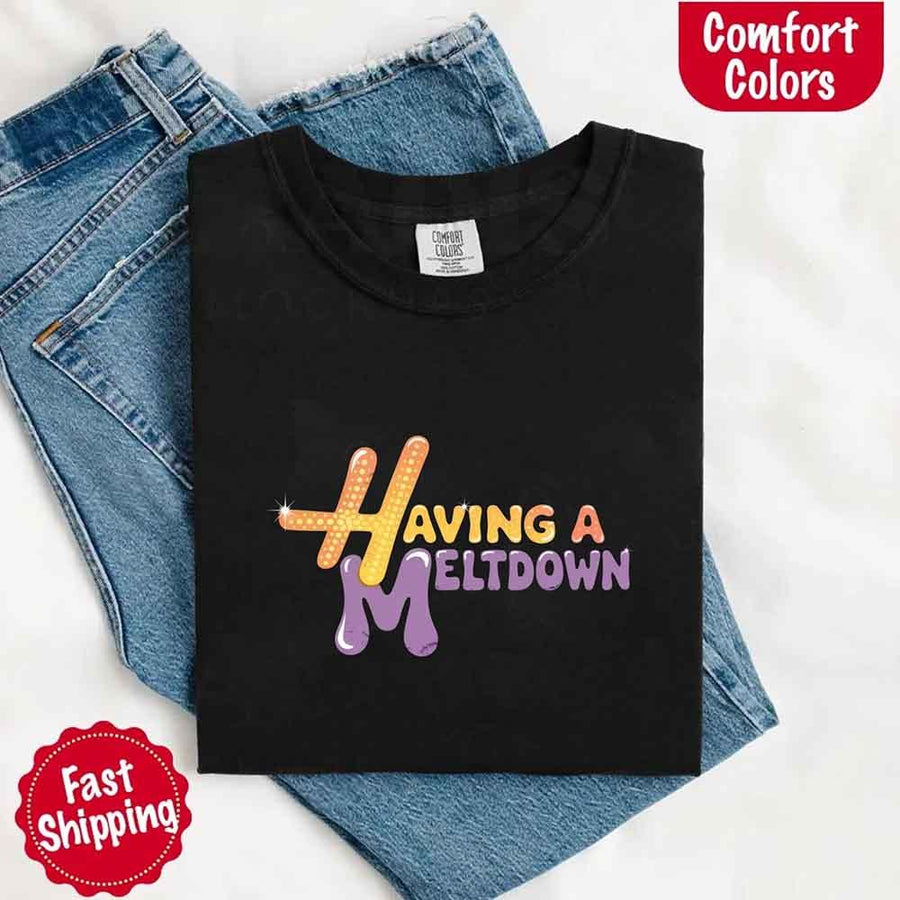 May include a woman wearing a black Comfort Colors T-shirt with the phrase “having a meltdown” in bold black text, styled for a humorous and relatable casual look.