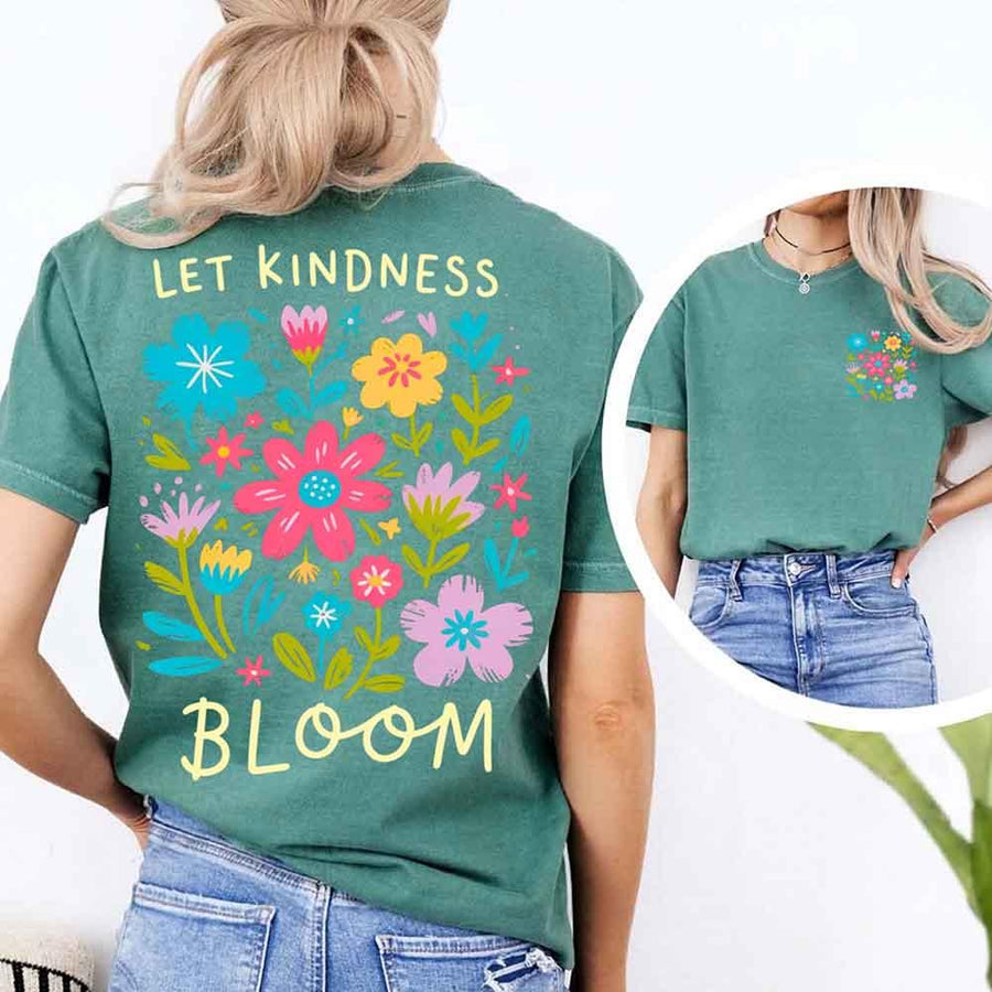 May include a woman wearing a Light Green Comfort Colors T-shirt with colorful floral graphics and the phrase “Let Kindness Bloom” printed on the back, styled with light denim for a cheerful and uplifting look.