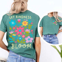 May include a woman wearing a Light Green Comfort Colors T-shirt with colorful floral graphics and the phrase “Let Kindness Bloom” printed on the back, styled with light denim for a cheerful and uplifting look.