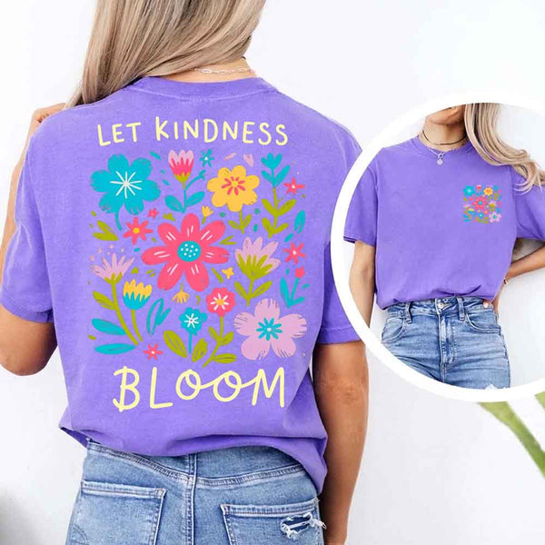 May include a woman wearing a Violet Comfort Colors T-shirt with colorful floral graphics and the phrase “Let Kindness Bloom” printed on the back, styled with light denim for a cheerful and uplifting look.