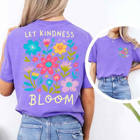May include a woman wearing a Violet Comfort Colors T-shirt with colorful floral graphics and the phrase “Let Kindness Bloom” printed on the back, styled with light denim for a cheerful and uplifting look.