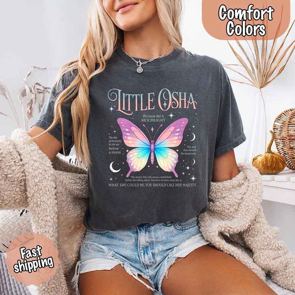 May include a woman wearing a Pepper Comfort Colors T-shirt featuring a delicate butterfly graphic inspired by Little Osha from Quicksilver, styled casually with denim for a soft and whimsical look.