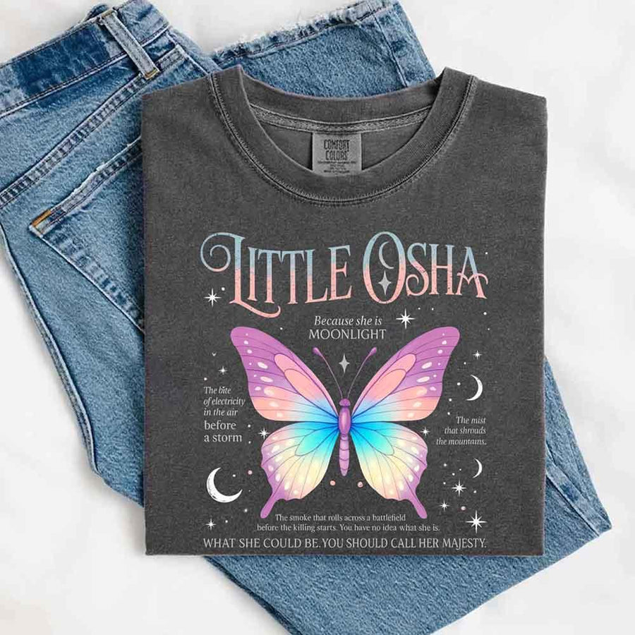 May include a folded Pepper Comfort Colors T-shirt with a Quicksilver-inspired butterfly design, neatly placed over denim jeans for a gentle and dreamy aesthetic.