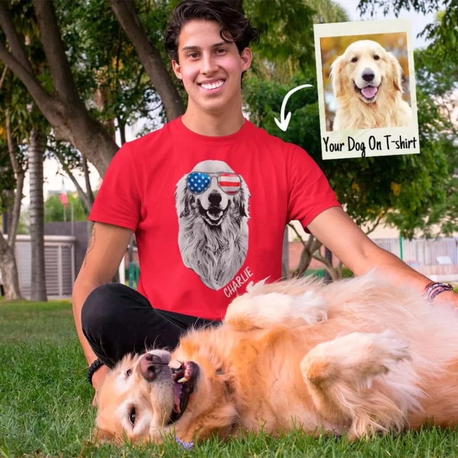 Person wearing a red t-shirt with a dog graphic and text, sitting with two dogs outdoors.