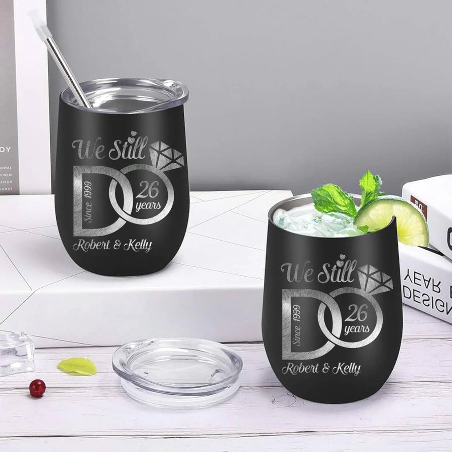 Two black tumblers with engraved text on a white surface
