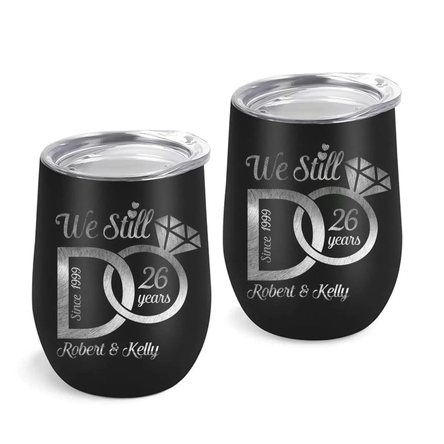 Two black tumblers with silver text and designs on a white background