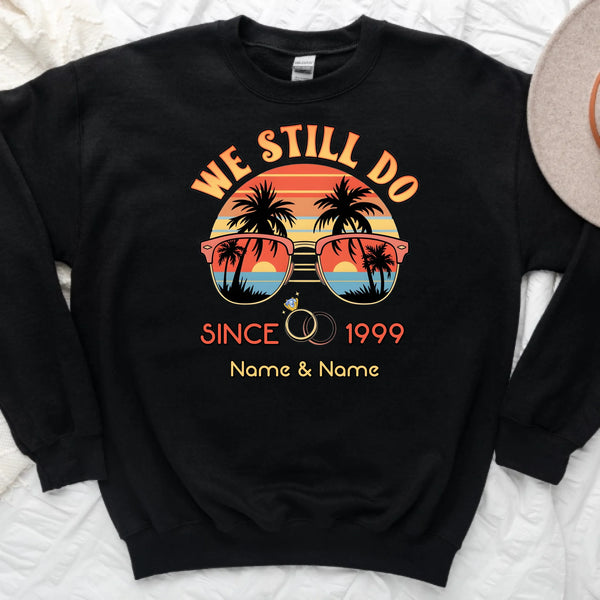 Black sweatshirt with 'We Still Do Since 1999' design featuring sunglasses and palm trees on a white background.