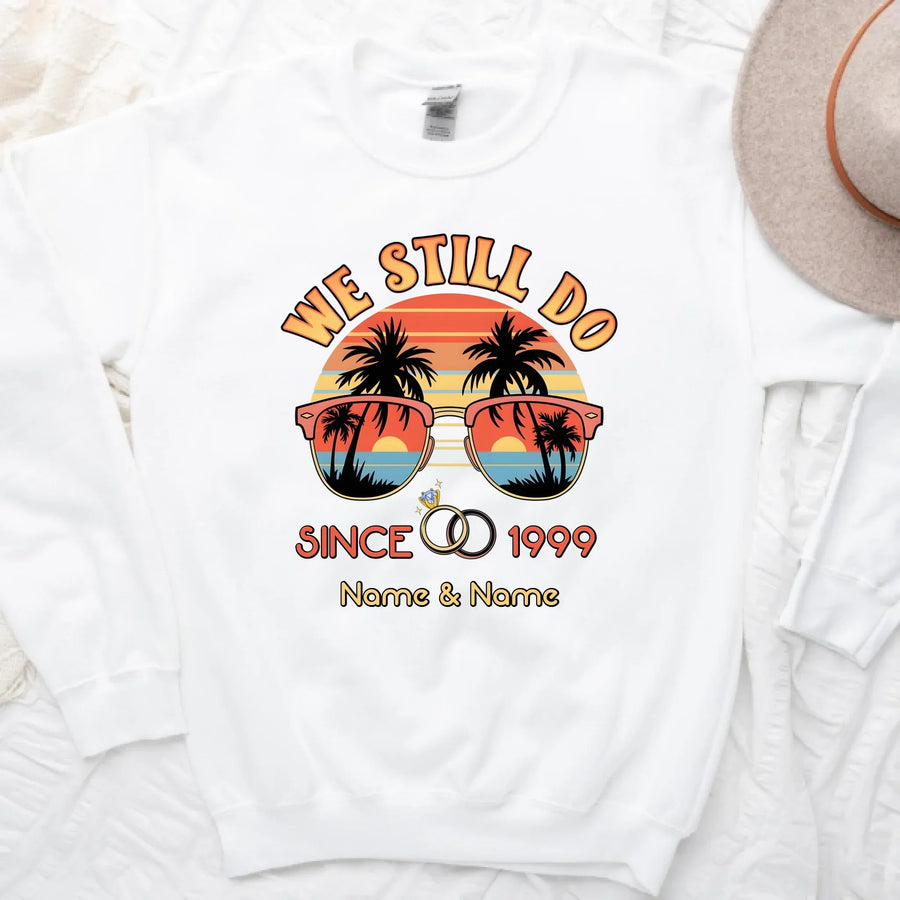 White sweatshirt with 'We Still Do Since 1999' design featuring sunglasses and palm trees on a white background.