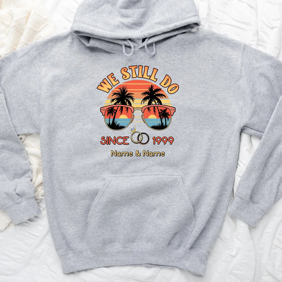 Gray hoodie with 'We Still Do Since 1999' design featuring sunglasses and palm trees on a white background.