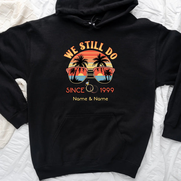 Black hoodie with 'We Still Do Since 1999' design on a white textured background