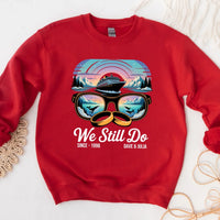 Red sweatshirt with cruise ship, sunglasses, and mountain graphic, text says 'We Still Do'
