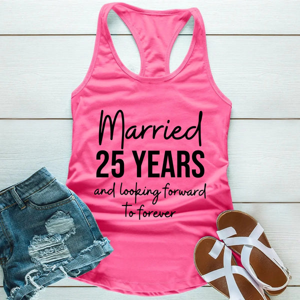 Pink tank top with text 'Married 25 Years and looking forward to forever' on a wooden surface with denim shorts and sandals.