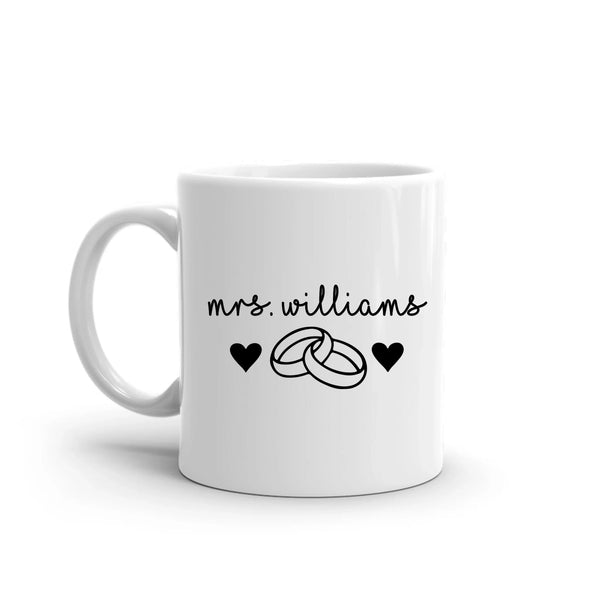 White mug with 'mrs. williams' and wedding ring design on a white background