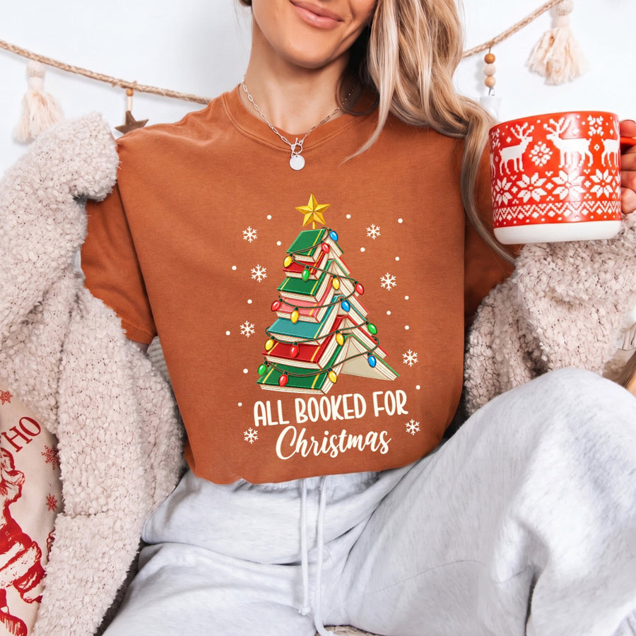 May include an All Booked for Christmas Book Lover Comfort Colors T-Shirt featuring a festive Christmas and reading-inspired design.