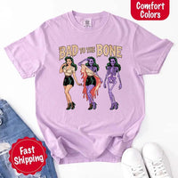May include Bad to the Bone graphic with retro pin-up girl transforming into purple skeleton artwork – vintage Halloween shirt.