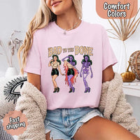 May include Bad to the Bone graphic with retro pin-up girl transforming into purple skeleton artwork – vintage Halloween shirt.