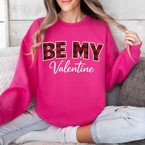 May include a buffalo plaid crewneck sweatshirt with Be My Valentine text printed on the front.