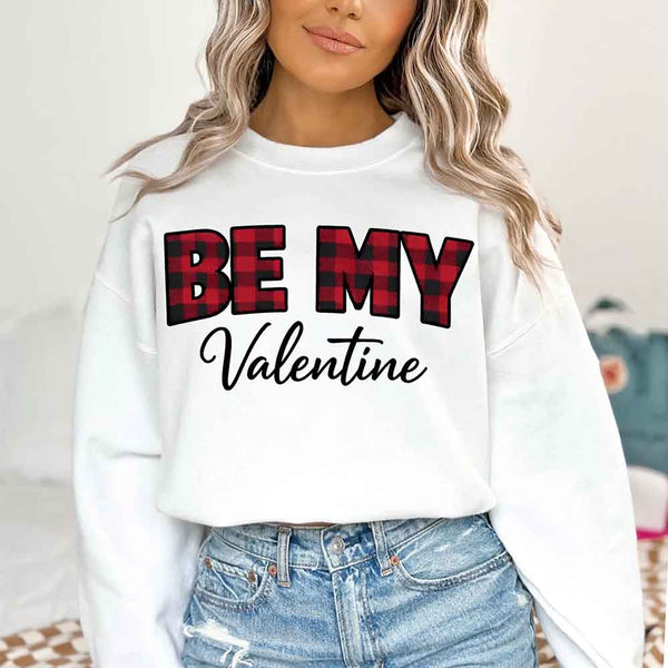 May include a buffalo plaid crewneck sweatshirt with Be My Valentine text printed on the front.