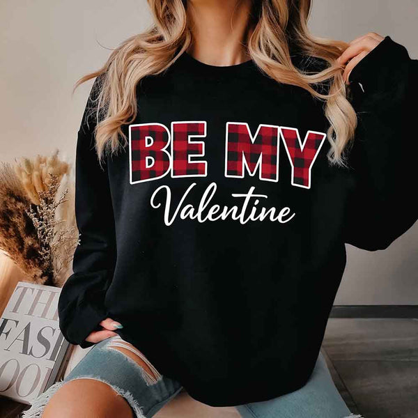 May include a buffalo plaid crewneck sweatshirt with Be My Valentine text printed on the front.