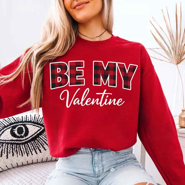 May include a buffalo plaid crewneck sweatshirt with Be My Valentine text printed on the front.