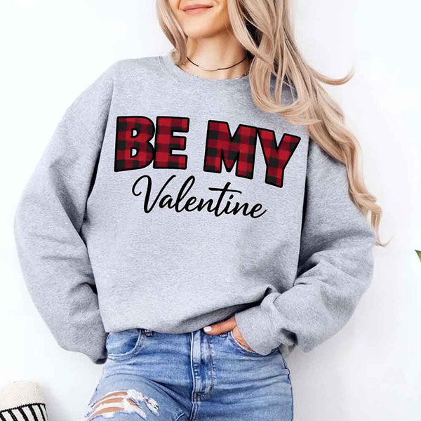 May include a buffalo plaid crewneck sweatshirt with Be My Valentine text printed on the front.
