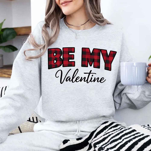 May include a buffalo plaid crewneck sweatshirt with Be My Valentine text printed on the front.