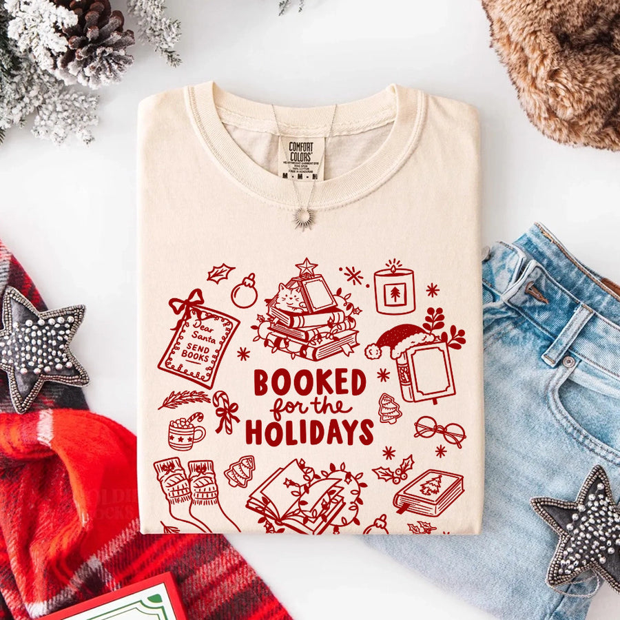 May include a Booked for the Holidays Comfort Colors T-Shirt featuring a festive Christmas and book-inspired statement design.