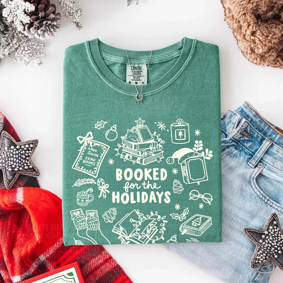 May include a Booked for the Holidays Comfort Colors T-Shirt featuring a festive Christmas and book-inspired statement design.