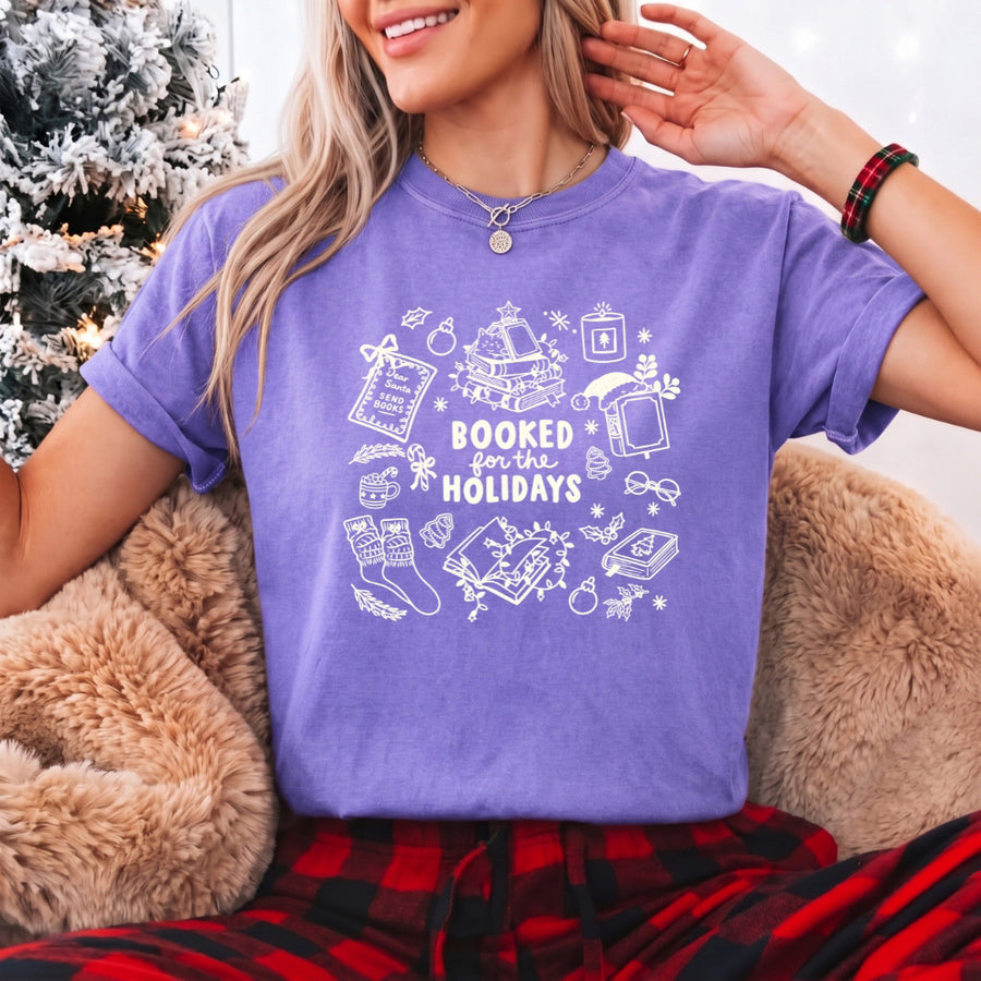 May include a Booked for the Holidays Comfort Colors T-Shirt featuring a festive Christmas and book-inspired statement design.