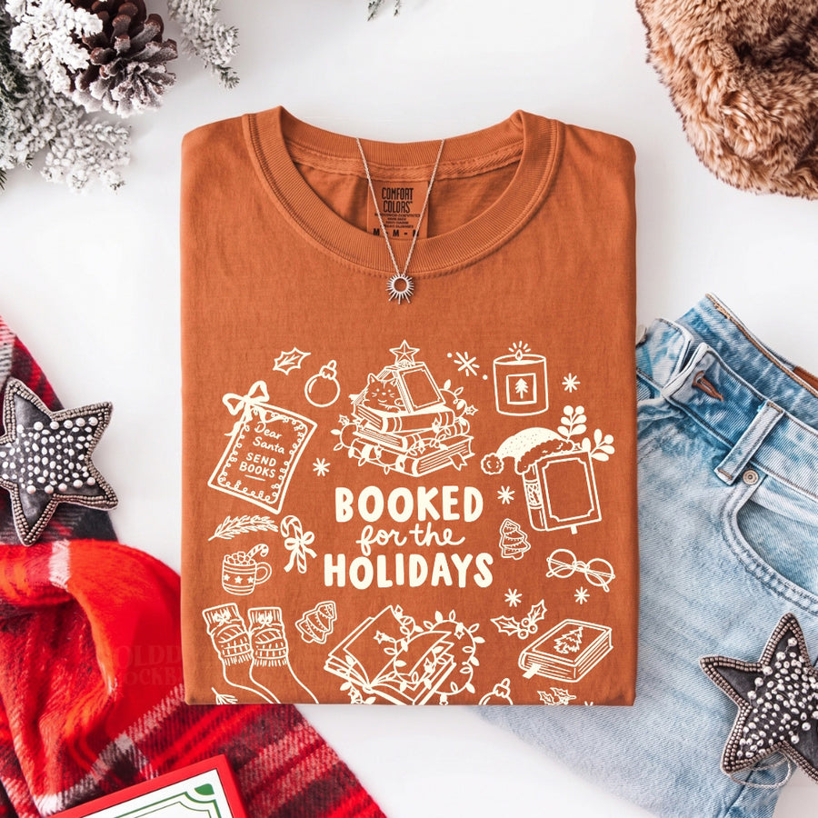 May include a Booked for the Holidays Comfort Colors T-Shirt featuring a festive Christmas and book-inspired statement design.