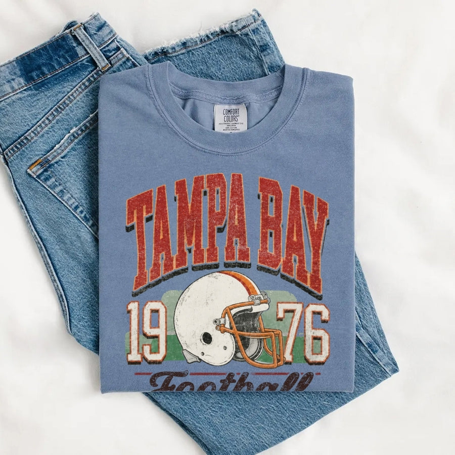 May include a City Football Comfort Colors T-Shirt featuring a football-inspired city graphic, relaxed unisex fit, and casual game-day style.