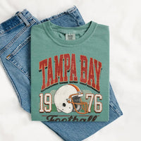 May include a City Football Comfort Colors T-Shirt featuring a football-inspired city graphic, relaxed unisex fit, and casual game-day style.
