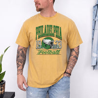 May include a City Football Comfort Colors T-Shirt featuring a football-inspired city graphic, relaxed unisex fit, and casual game-day style.