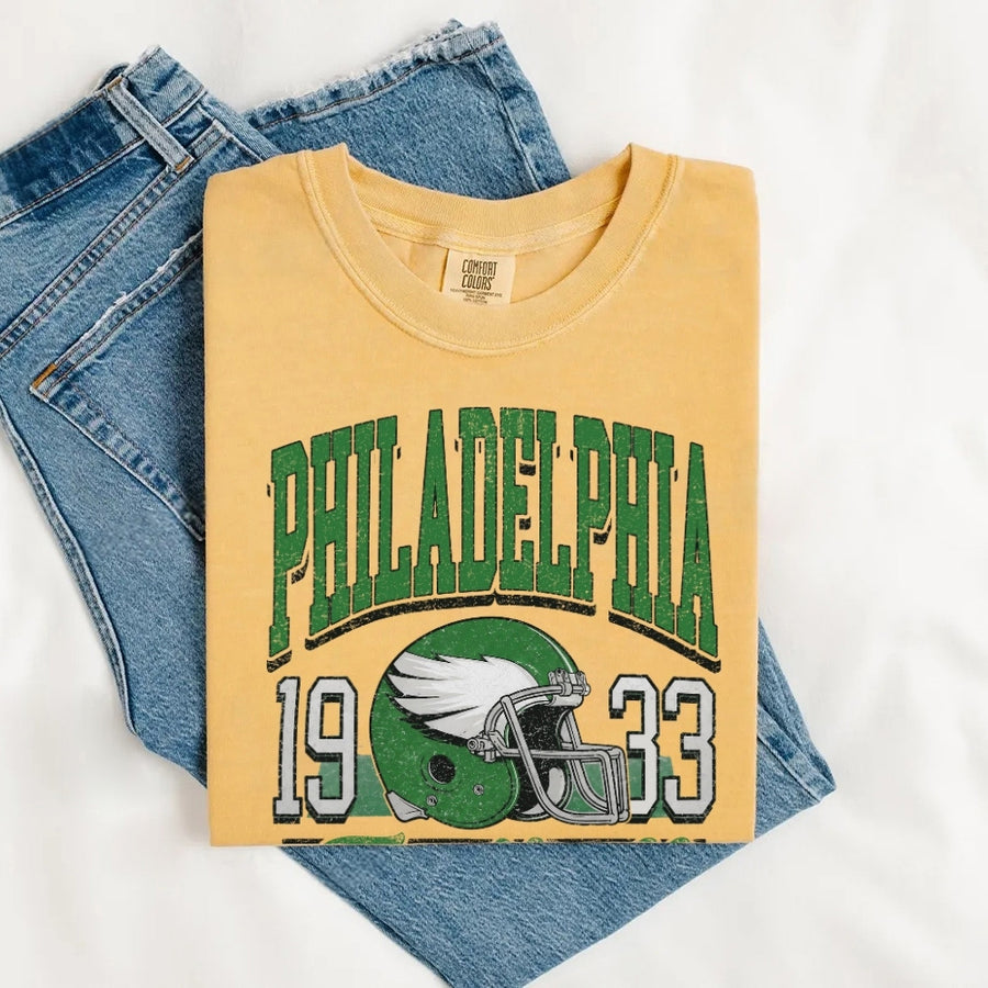 May include a City Football Comfort Colors T-Shirt featuring a football-inspired city graphic, relaxed unisex fit, and casual game-day style.
