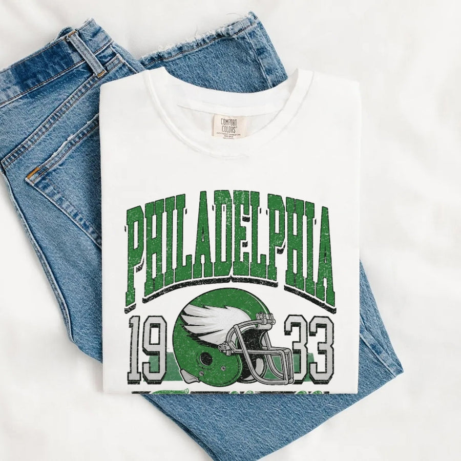May include a City Football Comfort Colors T-Shirt featuring a football-inspired city graphic, relaxed unisex fit, and casual game-day style.