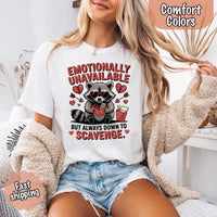 May include a red and black raccoon illustration wearing red sunglasses with the phrase “Emotionally Unavailable,” printed on a Comfort Colors tee for a bold, edgy vibe.