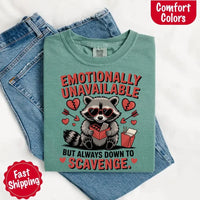 May include a red and black raccoon illustration wearing red sunglasses with the phrase “Emotionally Unavailable,” printed on a Comfort Colors tee for a bold, edgy vibe.