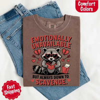 May include a red and black raccoon illustration wearing red sunglasses with the phrase “Emotionally Unavailable,” printed on a Comfort Colors tee for a bold, edgy vibe.
