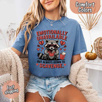 May include a red and black raccoon illustration wearing red sunglasses with the phrase “Emotionally Unavailable,” printed on a Comfort Colors tee for a bold, edgy vibe.