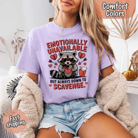 May include a red and black raccoon illustration wearing red sunglasses with the phrase “Emotionally Unavailable,” printed on a Comfort Colors tee for a bold, edgy vibe.