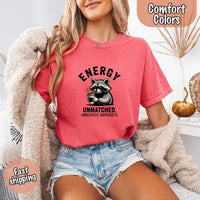 May include a black and white raccoon illustration with a tired, unbothered expression, holding a coffee cup, and bold text that reads “ENERGY UNMATCHED. UNMEDICATED. UNAPOLOGETIC.” conveying raw, unapologetic humor and mood.