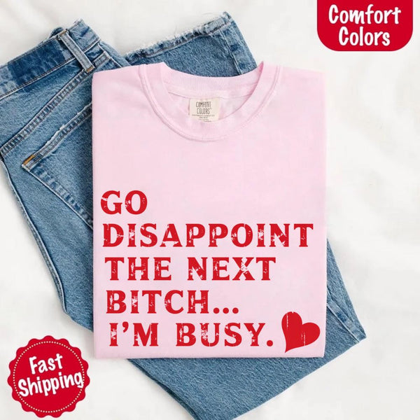 May include bold red distressed typography with the phrase “Go Disappoint The Next Bitch… I’m Busy.” alongside a red heart, expressing sass, confidence, and attitude.