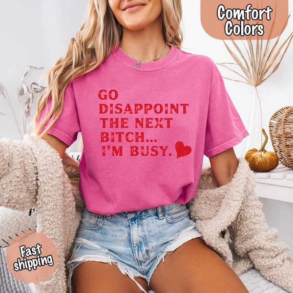 May include bold red distressed typography with the phrase “Go Disappoint The Next Bitch… I’m Busy.” alongside a red heart, expressing sass, confidence, and attitude.